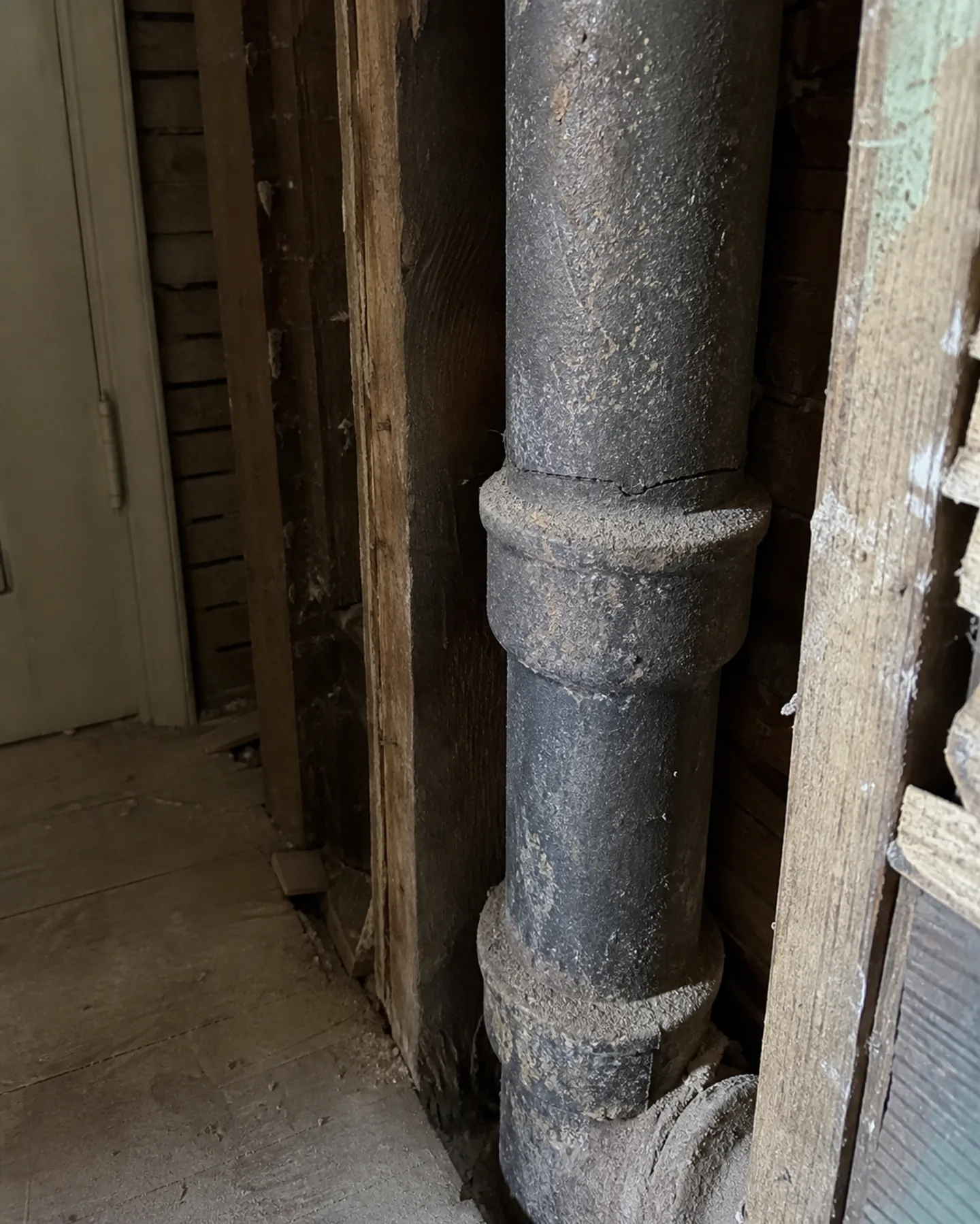 Aging cast iron drain pipe exposed for inspection